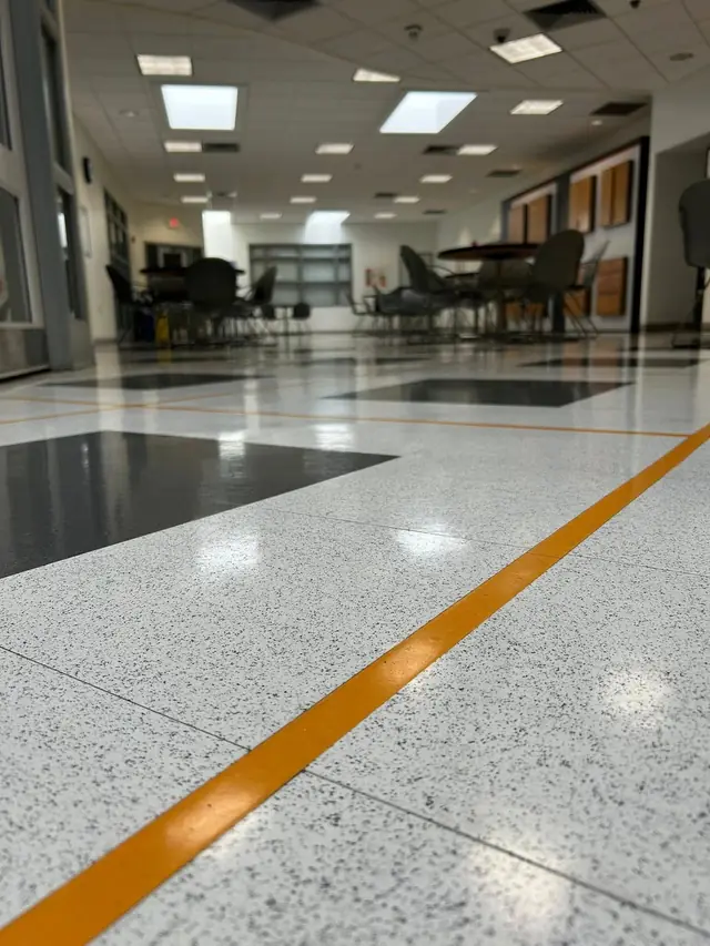 A low angle view of polished terrazzo with a painted yellow safety line